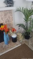Wide view showing all items including vases with faux leaves, large faux palm plant, decorative boxes, and Buddha statue.