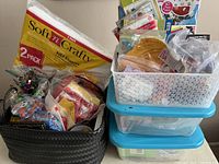 Photo of black and white baskets filled with assorted craft and party supplies including tissue paper, colorful paper, and decorative items.