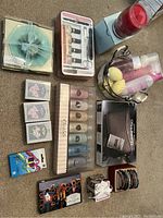 Photo of a variety of gift items including bracelets, manicure nails sets, stationery, shower gels, and a wind chime placed on a blanket.
