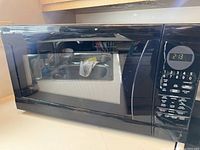 Front view of the Sharp Carousel microwave showing the door, digital clock, and control buttons.