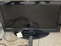 Black Toshiba small television approximately 28x16 inches with remote control and HDMI cable.