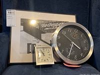 Photo showing the Hito wall clock, Seiko alarm clock, and Dr Pepper wall art grouped together on a couch.
