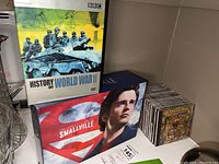 Shelf display showing History of World War II DVD, Smallville DVD box set, and multiple music CDs