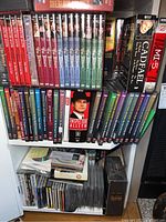 Shelf showing The Pallisers DVD series volumes 1-12 in red, blue, and green cases; Inspector Morse DVDs; other assorted DVDs and CDs below.