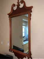 Full view of rectangular framed mirror hung on a wall, showing wooden frame and reflective glass.