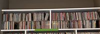 View of two rows of CDs on a white shelf showing a variety of classical and easy listening music titles.