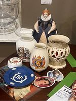 Franklin Porcelain Elizabeth I figurine, decorative vases, ashtray, and magnets on table