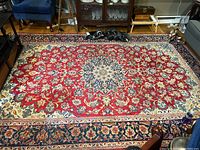 Full view of rug showing central medallion, red field and navy border