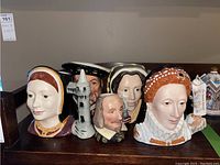 Front view of five Toby mugs showing faces and detailed painting