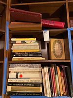 Middle and bottom shelves showing a variety of books including Opera, sports, art, Shakespeare, and magazines.