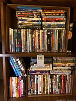 Two shelves packed with DVD cases showing variety of movie and documentary titles along with TV series.