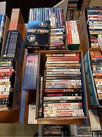 Overhead photo showing multiple DVD boxed sets including Godfather Collection, Scorsese boxed set, and a variety of comedy and classic films in standard DVD cases.