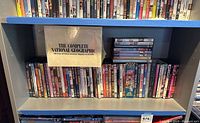 Photo showing a large collection of DVDs on a shelving unit including The Complete National Geographic set and many assorted titles.