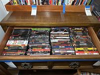 Top view shot showing a wide collection of horror and thriller DVDs in a wooden case drawer.