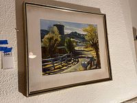 Frontal view of framed landscape artwork hung on wall