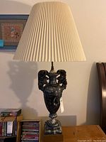 Full view of marble table lamp with cream pleated shade, showing overall shape and size.