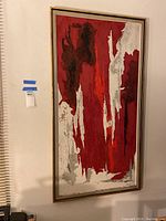 Full view of the textured abstract painting showing red, white, grey, and black colors within a framed mount on wall.