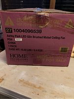 Box showing product label stating 'Ashby Park LED 52in Brushed Nickel Ceiling Fan' by Home Decorators Collection. Original store display packaging with markings indicating 'Display Only Not For Sale'.