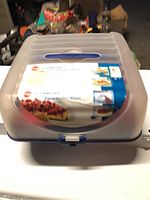 Front view of the closed party tray carrier showing the frosted lid with handle and original packaging label.