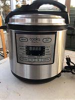 Front view of the stainless steel Cooks Fast Pot with digital display showing cooking functions and buttons.