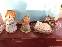 Front view showing four vintage light figurines: angel, bird, sleeping cat, and Charming Tails mouse and bird statue.