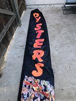 Photo of one of the two 15-foot long vertical black fabric advertising signs displaying the word 'OYSTERS' in orange letters with images of oysters at the bottom.