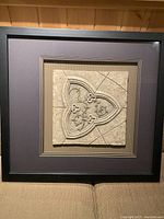 Close frontal photo of the first framed decorative stone-like tile with quatrefoil pattern