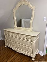 Full view of cream girls dresser with ornate attached mirror, showing decorative detailing on top and side.
