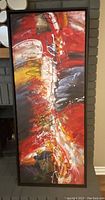 Full view of abstract framed painting showing vibrant brush strokes in multiple colors with a black frame.