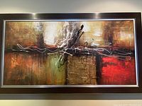 Front view of framed abstract painting with brown and red warm tones, metal silver inner frame detail.