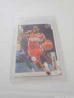 Front view of Allen Iverson rookie basketball card in protective sleeve showing player in Philadelphia 76ers uniform with Encore and Rookie markings.