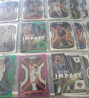 Collection of basketball rookie cards in plastic sleeves, showing front of cards and player images.