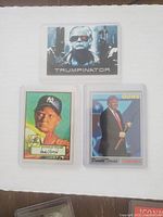 Top photo showing three Donald Trump-themed collectible trading cards, including a 'Trumpinator' parody card, a classic baseball style card, and a card showing Trump with a gun labeled 'GUNS'.