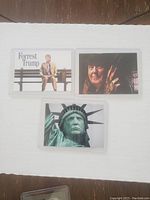 Three collectible cards featuring Forrest Trump parody, clawed figure, and Statue of Liberty close-up.