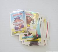 Stack of Garbage Pail Kids cards showing Mouth Phil and Rock E. Horror cards on top, colorful cartoon characters with exaggerated facial features.