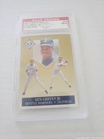 Front view of graded Ken Griffey Jr. baseball card showing player images, gold background, and P.A.A.S. grading label.