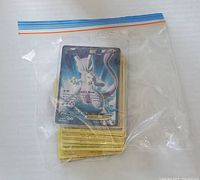 Front view of Mewtwo EX card on top of stack inside plastic bag