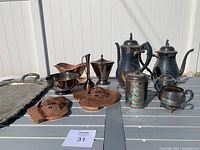 Image of entire coffee service set including servers, creamers, sugar bowl, cookie cutters, tray, bud vase and bowls on table against white background
