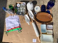 Full lot overview including glass jars, white ceramic pieces, brown oval baking dish, Pyrex ovenware and mesh bags