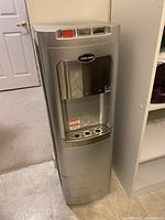 Full front view of the silver Black & Decker water dispenser showing the dispensing area and drip tray.