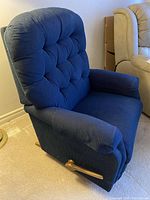 Side view of blue La-Z-Boy rocker recliner chair showing tufted backrest, padded armrest, and wooden lever.