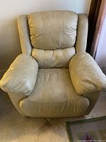 Front view of the cream coloured leather recliner showing cushioned seat, back, and armrests.