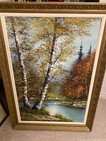 Front view of the framed artwork showing the birch tree landscape beside a river in autumn colors.