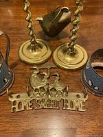 Brass candleholders, brass pot, enamel cup holders, and brass 'Home Sweet Home' plaque