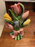 Front view showing the tulip bouquet painted in yellow, pink, red, purple, green, and pink bow details