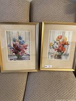 Pair of framed floral watercolor paintings arranged side by side, showcasing the full pieces including gold-tone frames and mats.