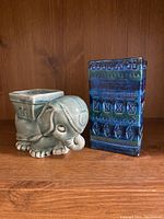 Front view of the two blue-green ceramic vases, elephant-shaped and rectangular patterned vase.