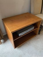 Photo showing front and right side of teak wood TV media centre with a VCR placed on the middle shelf.