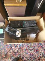 Top view of box containing Sony CD player, receiver, remotes, and accessories.