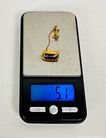 Fraternity pin placed on a digital scale reading 5.1 grams.